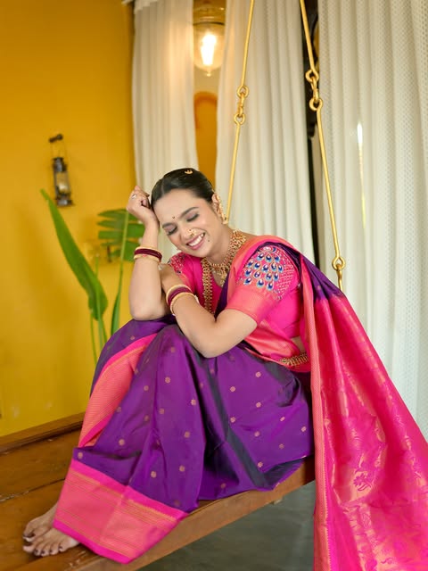 Seated bridal portrait in a purple and pink sari beside a warm yellow doorway, from Pooja Salunkhe Makeover's portfolio